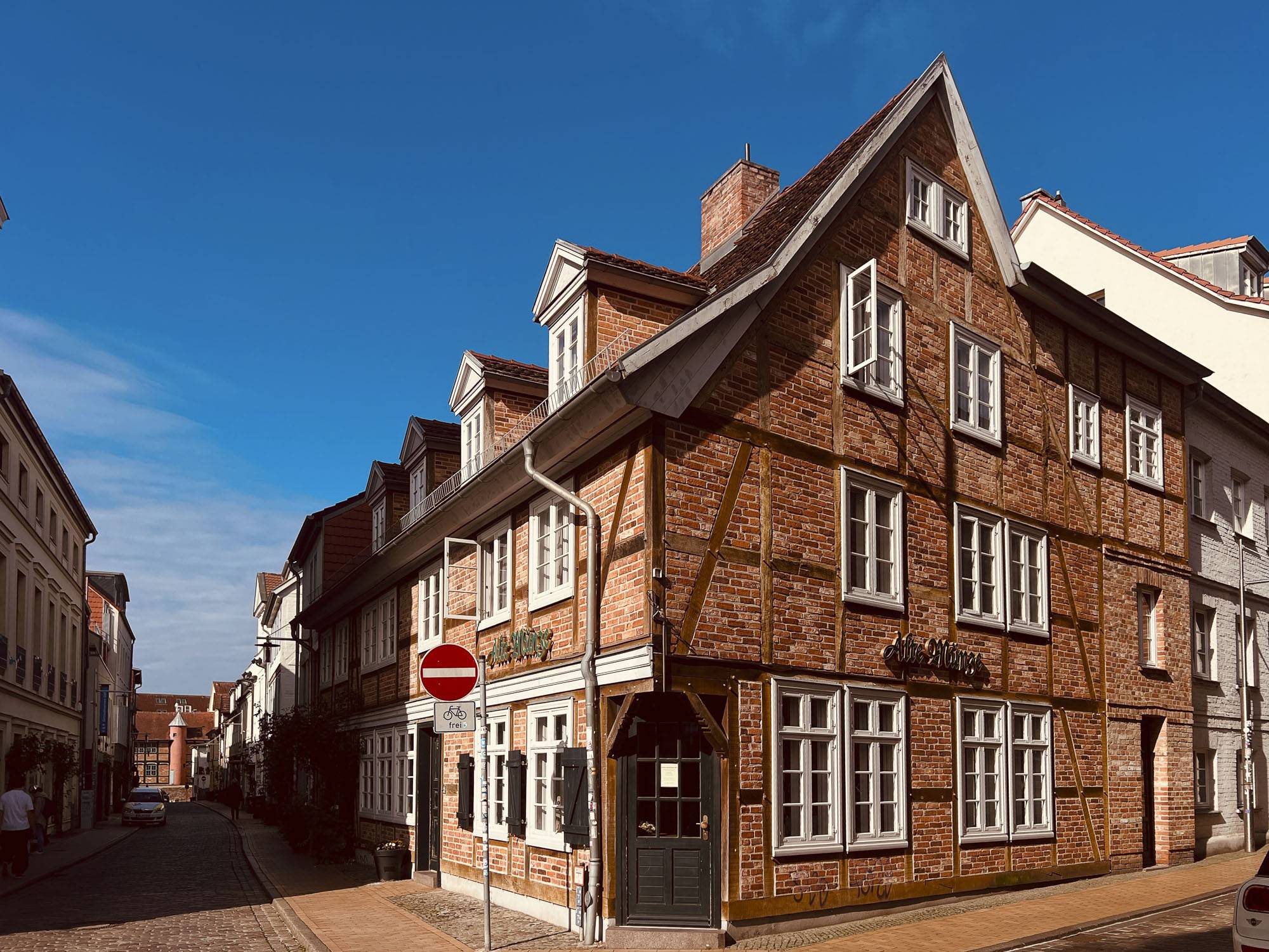Fachwerkhaus Alte Münze in der Münzstraße in der Schweriner Altstadt bei sonnigem Wetter, historisches Gebäude mit roter Backsteinfassade und weißen Sprossenfenstern.